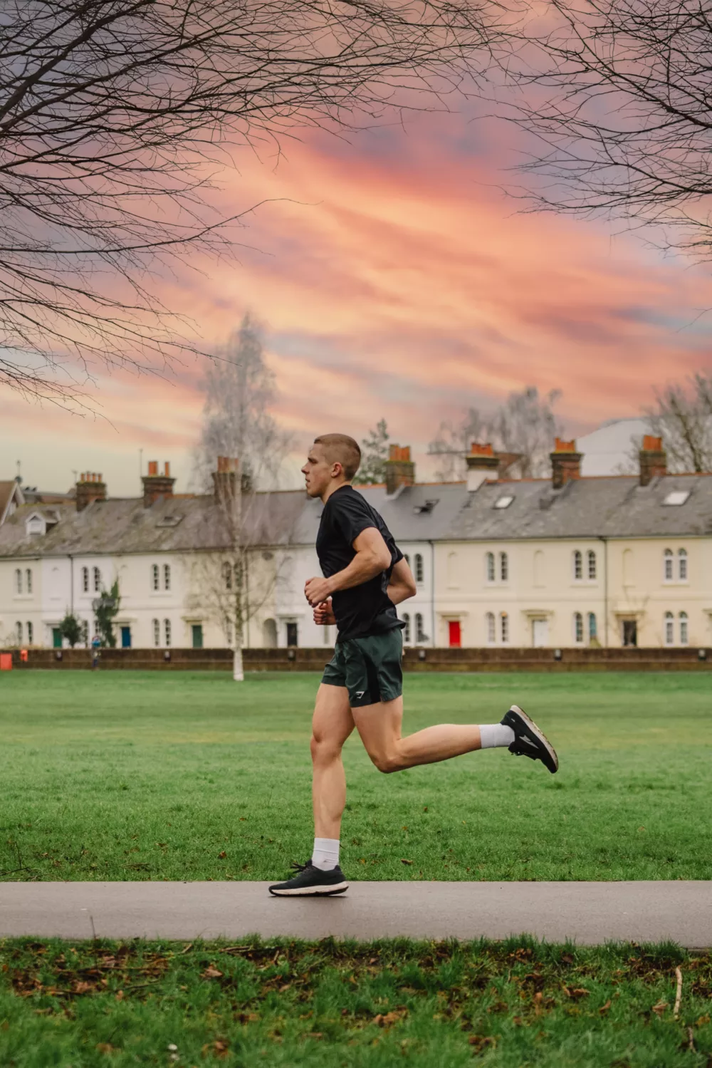 man running on a sidewalk in a park